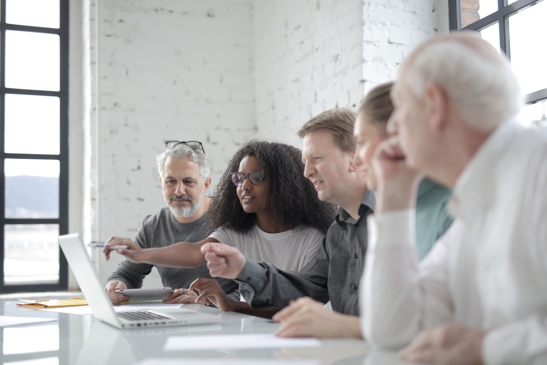 Stock photograph of a multigenerational team collaborating around a laptop; not actual iLAB participants